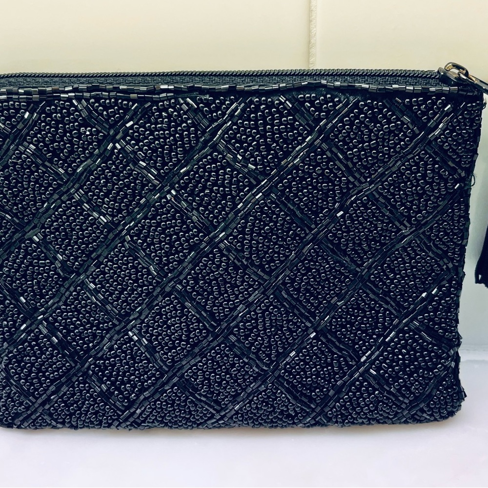 Small beaded pouch with zipper closure and satin linterior.